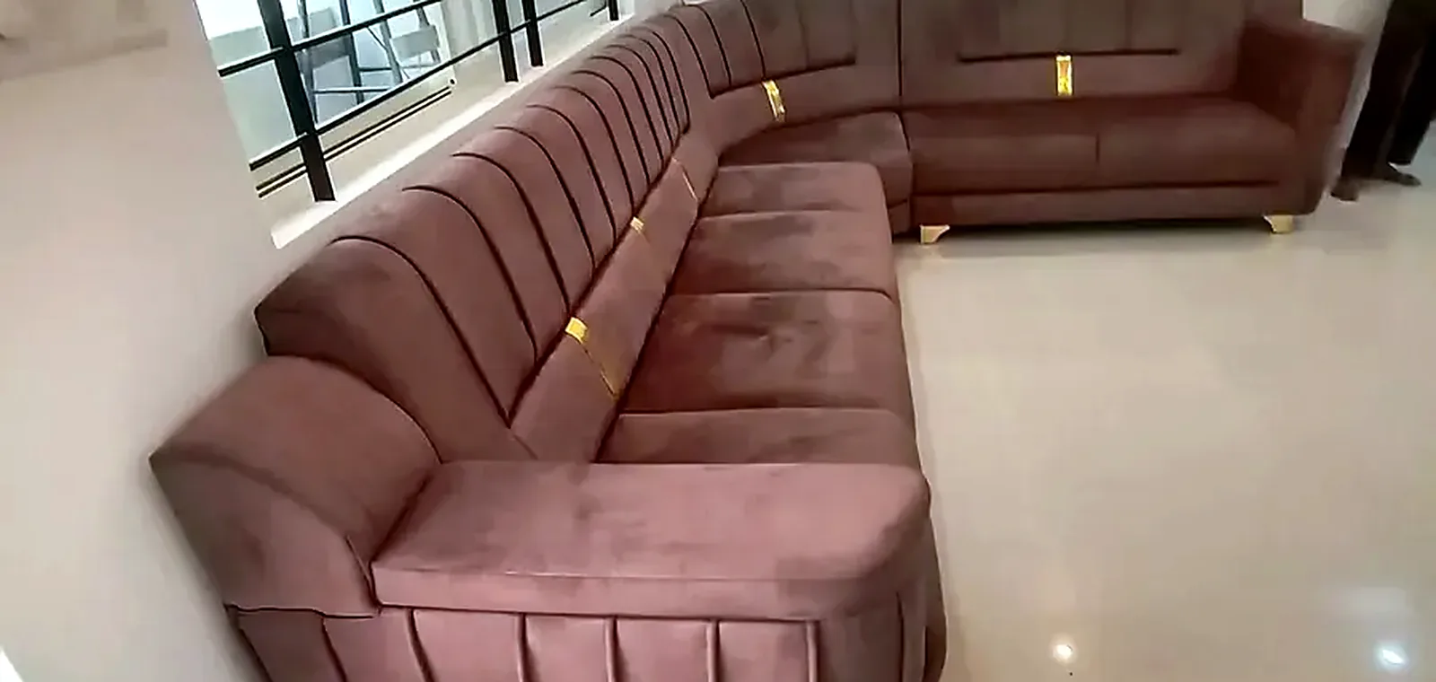 A curved sectional in a muted rose weave