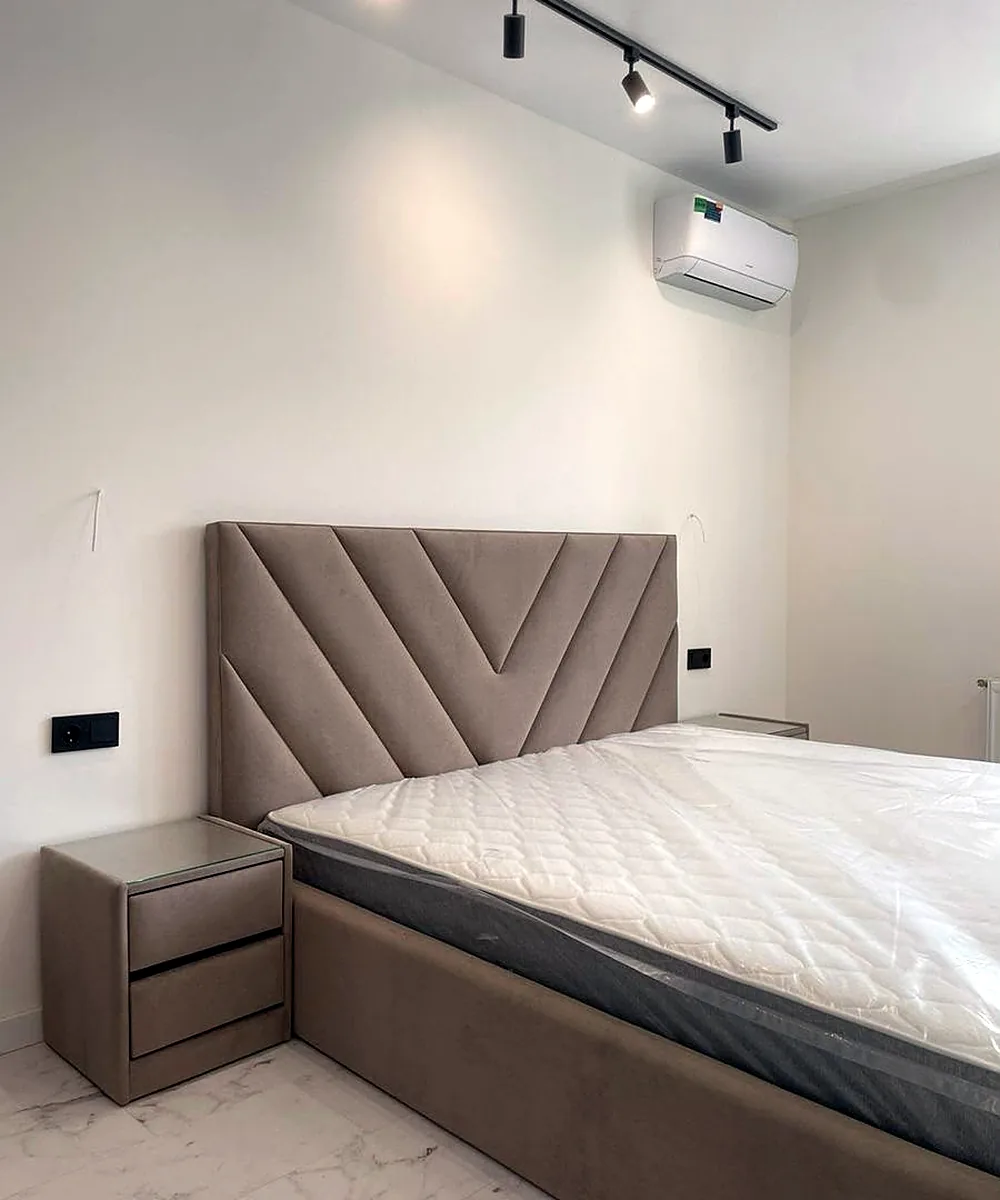 Chevron-panelled headboard in a made-up bedroom