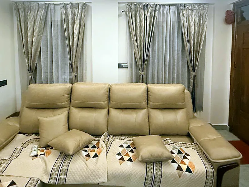 A tan corner sofa with cushions, in a customer's living room