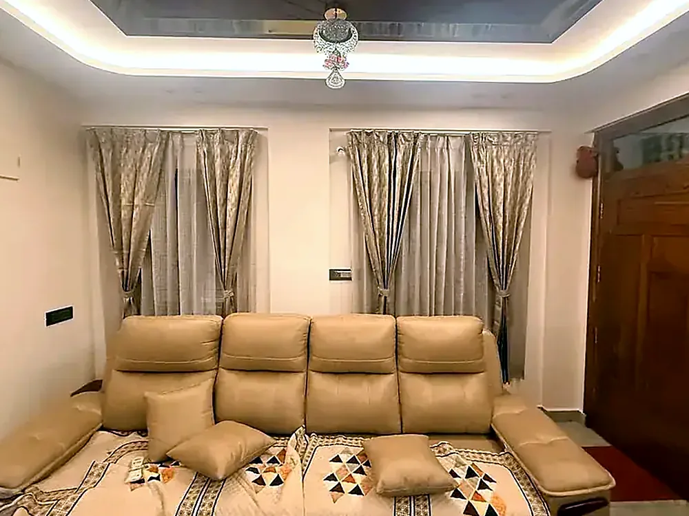 Tan fabric five-seat sofa under a cove-lit ceiling